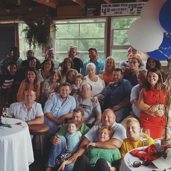 Large group of smiling people, including families and children, gathered inside Trooper Thorn's Irish Beef House.